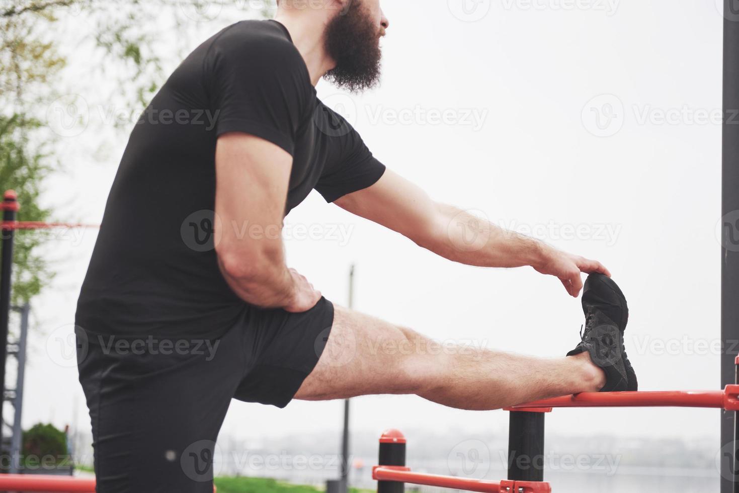 Der bärtige junge Mann betreibt Outdoor-Sport foto