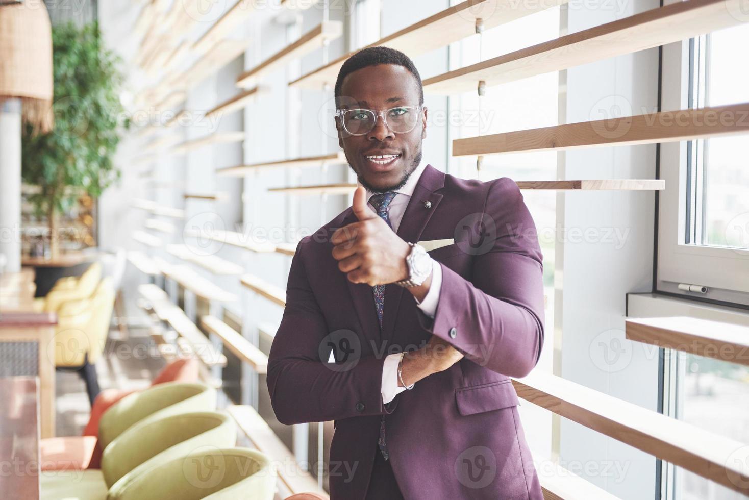 glückliches Lächeln eines erfolgreichen afroamerikanischen Geschäftsmannes im Anzug foto