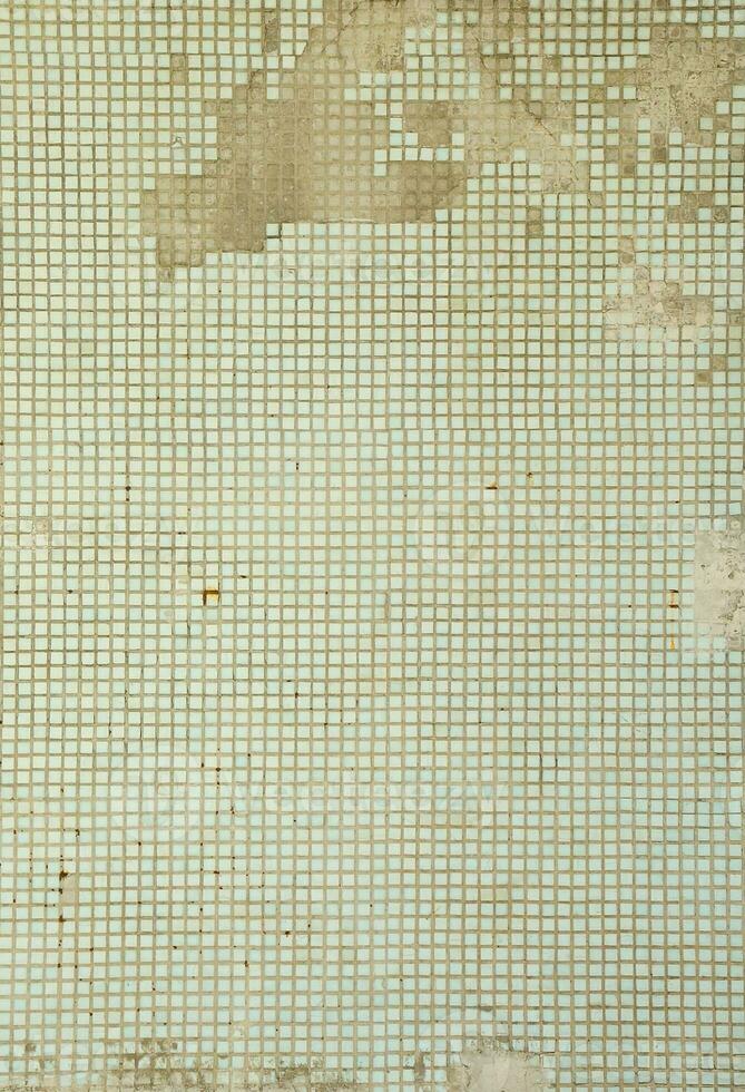 die textur der alten mauer, verziert mit vielen quadratischen kleinen fliesen. Wand im Stil der Architektur der Sowjetunion foto