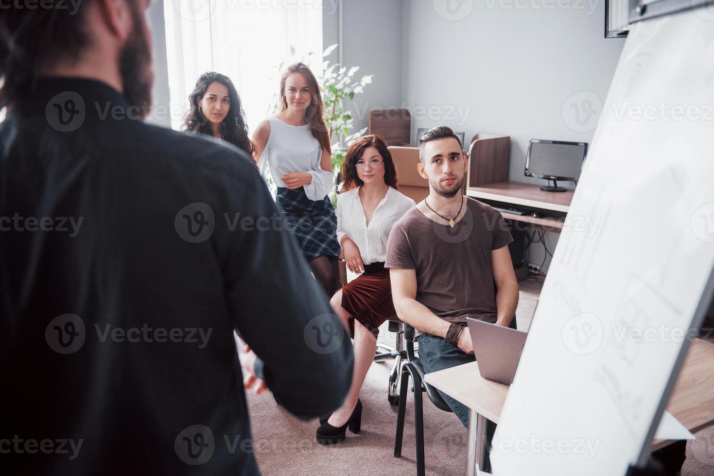 Gruppe junger Geschäftsleute, die im Kreativbüro zusammen arbeiten und kommunizieren foto