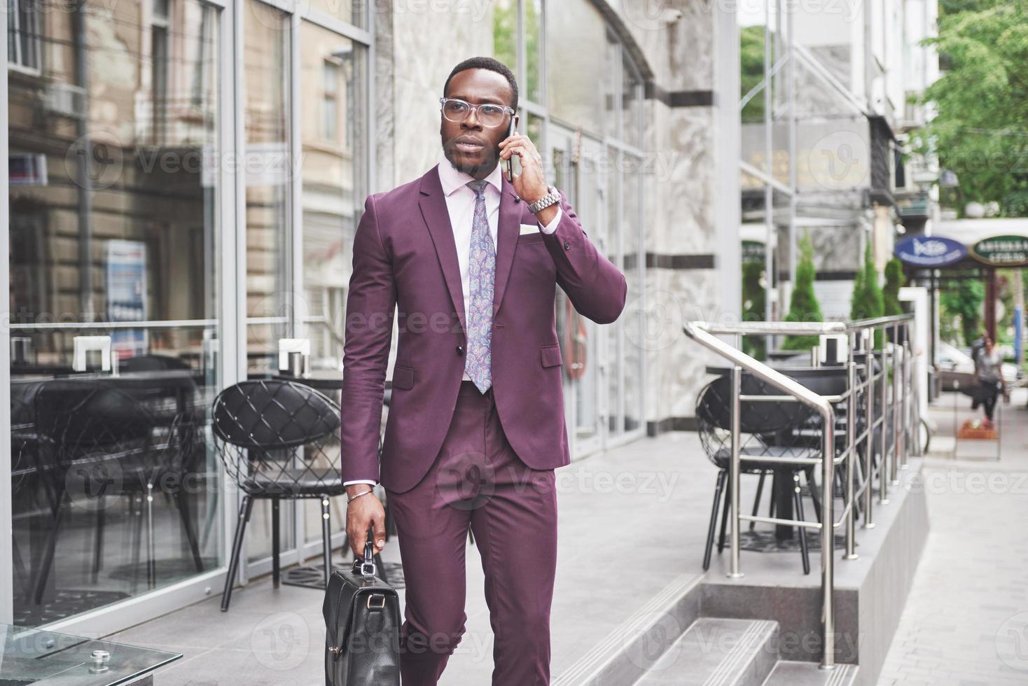 Porträt eines jungen schönen afroamerikanischen Geschäftsmannes mit einer Aktentasche. Geschäftstreffen. foto