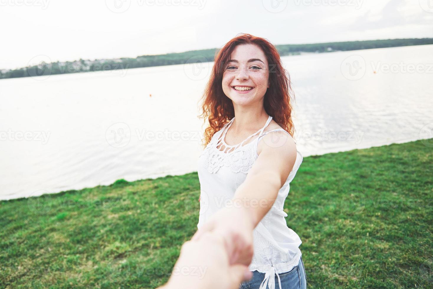 eine lächelnde glückliche frau mit einem verspielten ausdruck und einer hand mit ihrem mann. foto