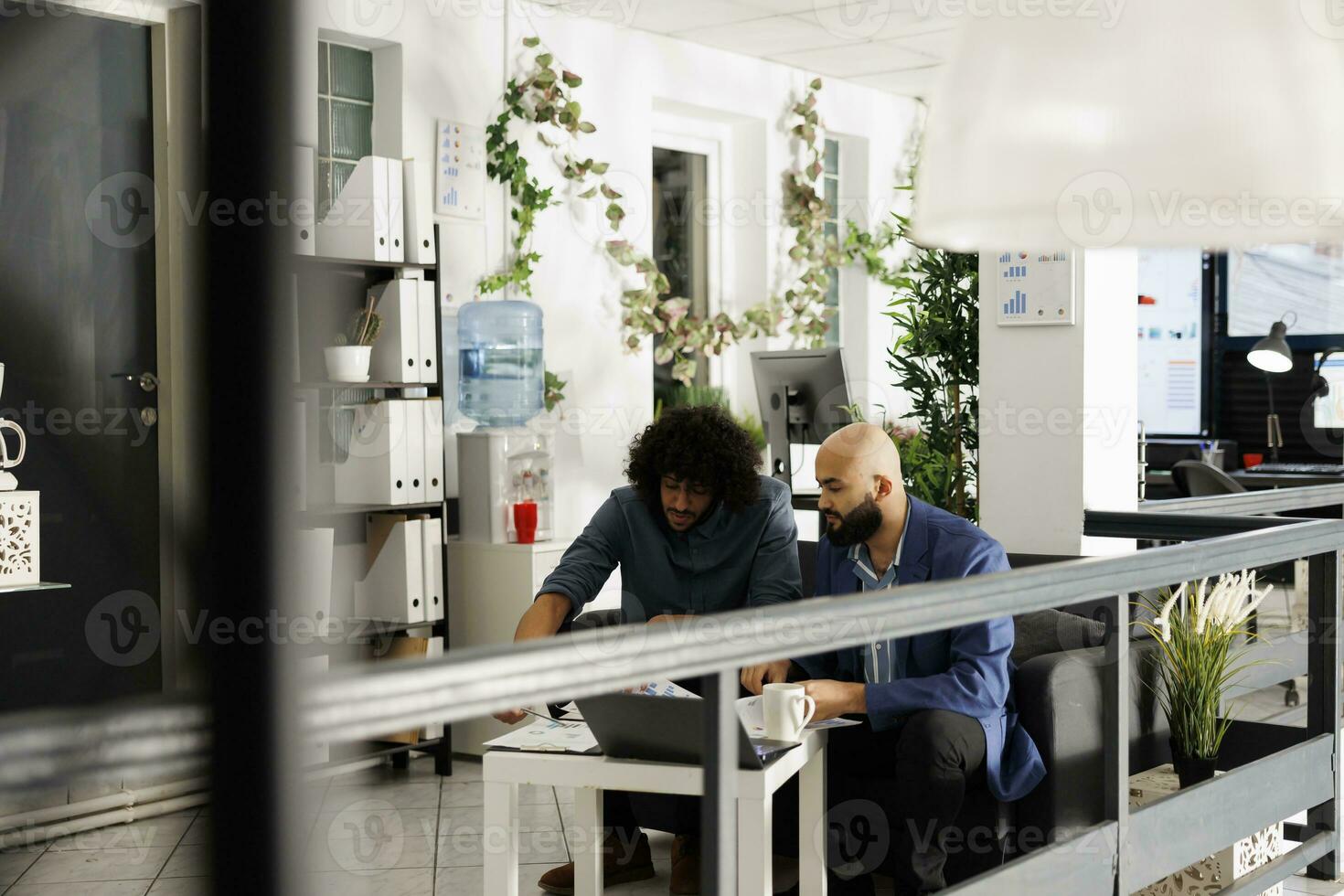 Anfang Mannschaft Überprüfung finanziell Bericht auf Zwischenablage im Geschäft Büro Arbeitsplatz. arabisch Mitarbeiter diskutieren Projekt Strategie während Sitzung auf Couch im Grün Coworking Raum foto