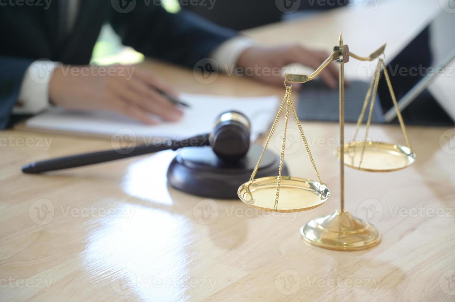 Konzept der Gerechtigkeit, Anwalt, der einen Hammer hält, der vorgibt, auf ein Holztablett zu schlagen, das auf den Schreibtisch gestellt wird. foto