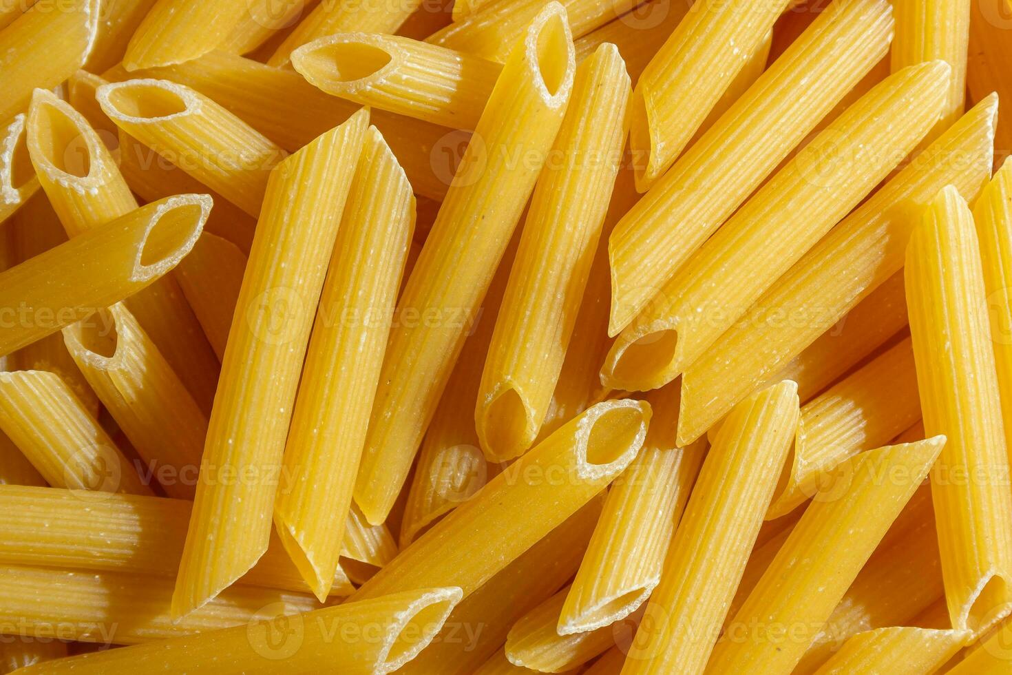 ungekocht Penne rigate Pasta. ein kulinarisch Segeltuch von Penne Makkaroni, Erstellen ein lebhaft und texturiert Hintergrund zum Gourmet Kochen. trocken Pasta. roh Makkaroni - - oben Sicht, eben legen foto