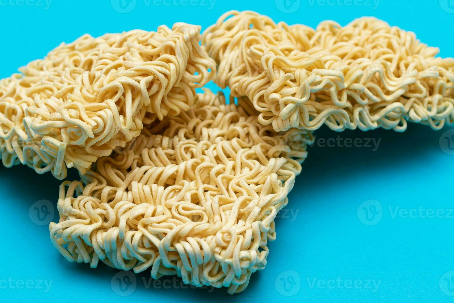 ungekocht sofortig Nudeln auf Blau Hintergrund. roh Pasta. trocken asiatisch schnell Lebensmittel. schnell Mittagessen foto