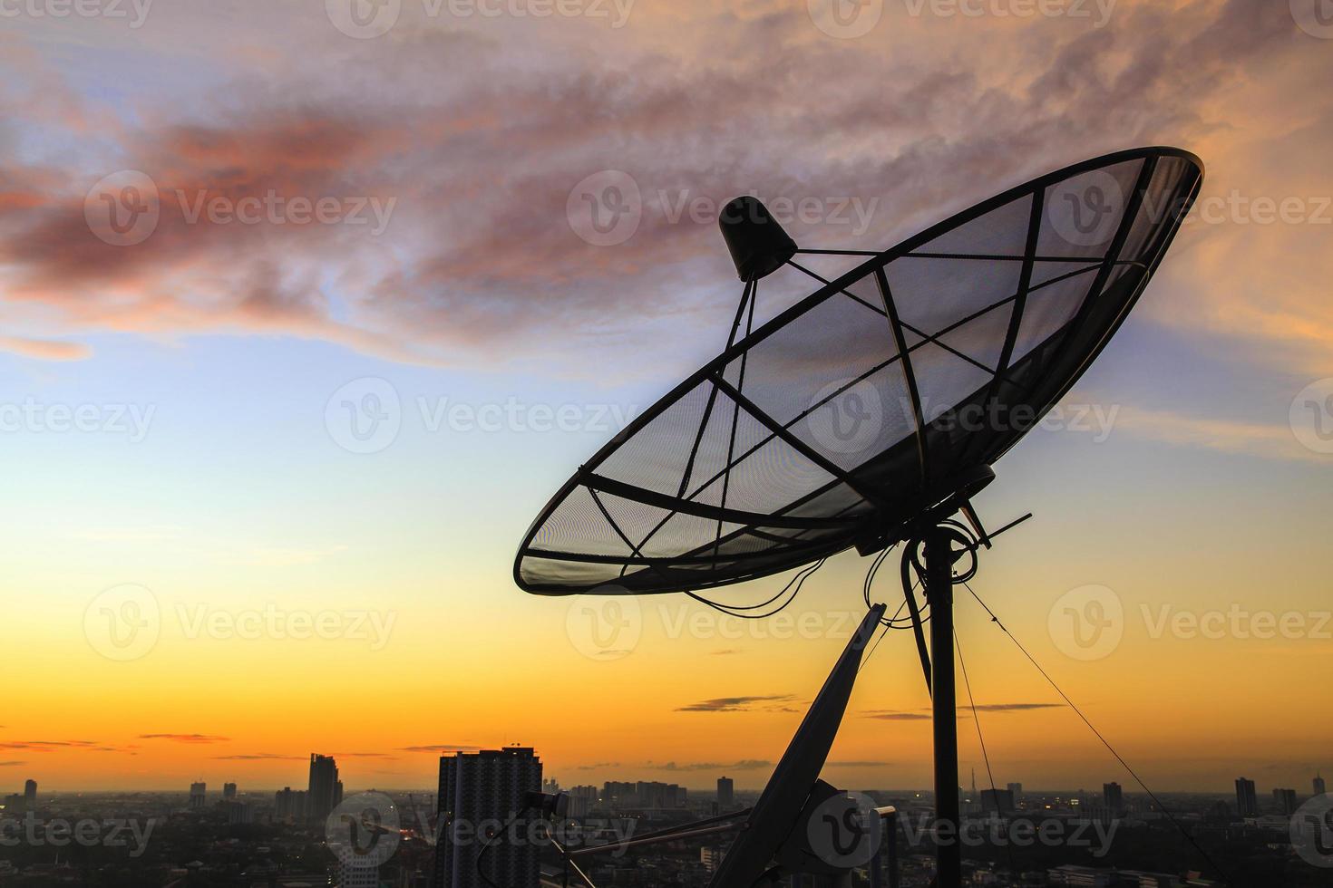 Silhouette einer Satellitenschüssel bei Sonnenuntergang foto