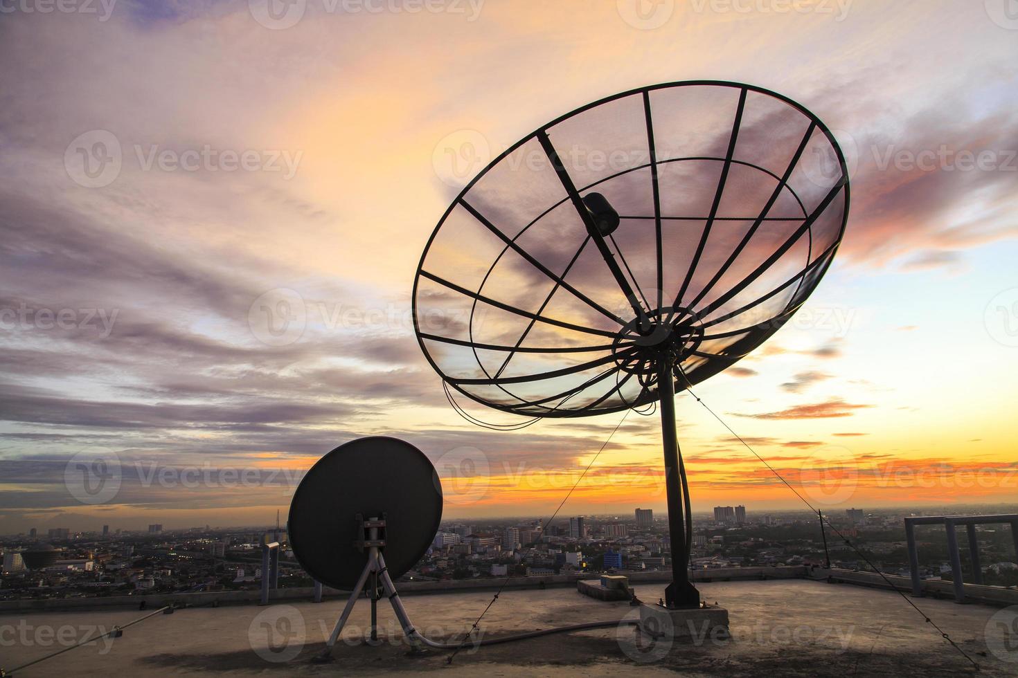 Silhouette einer Satellitenschüssel bei Sonnenuntergang foto