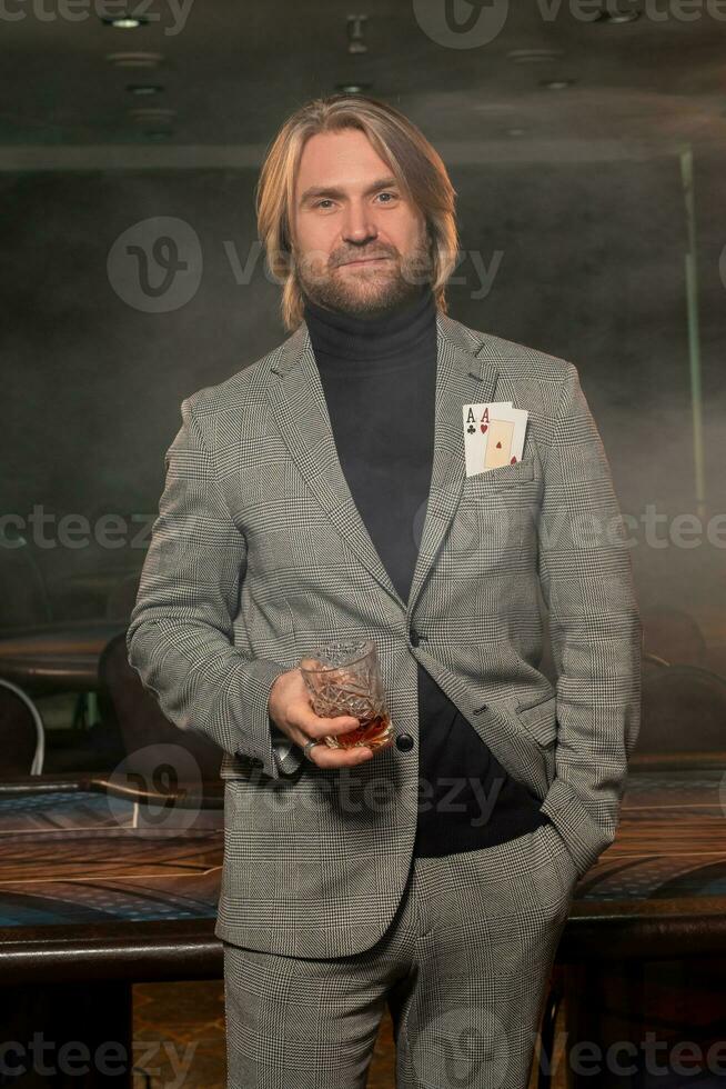 Poker Spieler mit Glas von trinken und Asse im Jacke Tasche bereit zum Risiko im Kasino foto