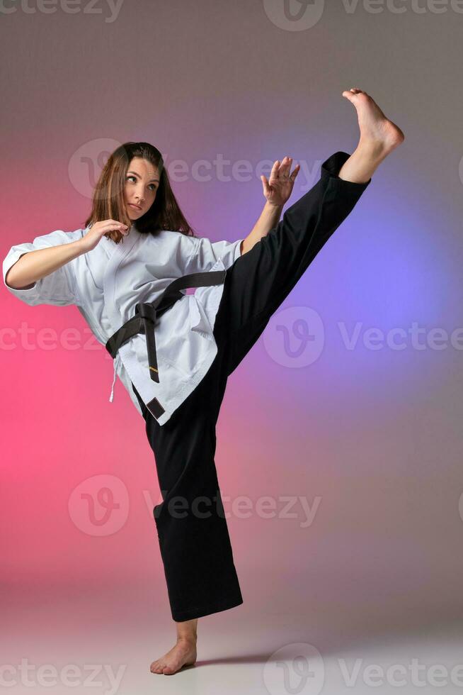 sportlich Frau im traditionell Kimono ist üben Karate im Studio. foto