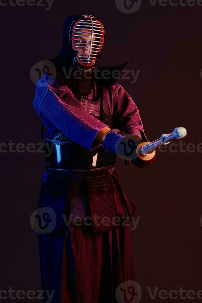 schließen oben Schuss, Kendo Kämpfer tragen im ein Rüstung, traditionell Kimono, Helm üben kriegerisch Kunst mit shinai Bambus Schwert, schwarz Hintergrund. foto