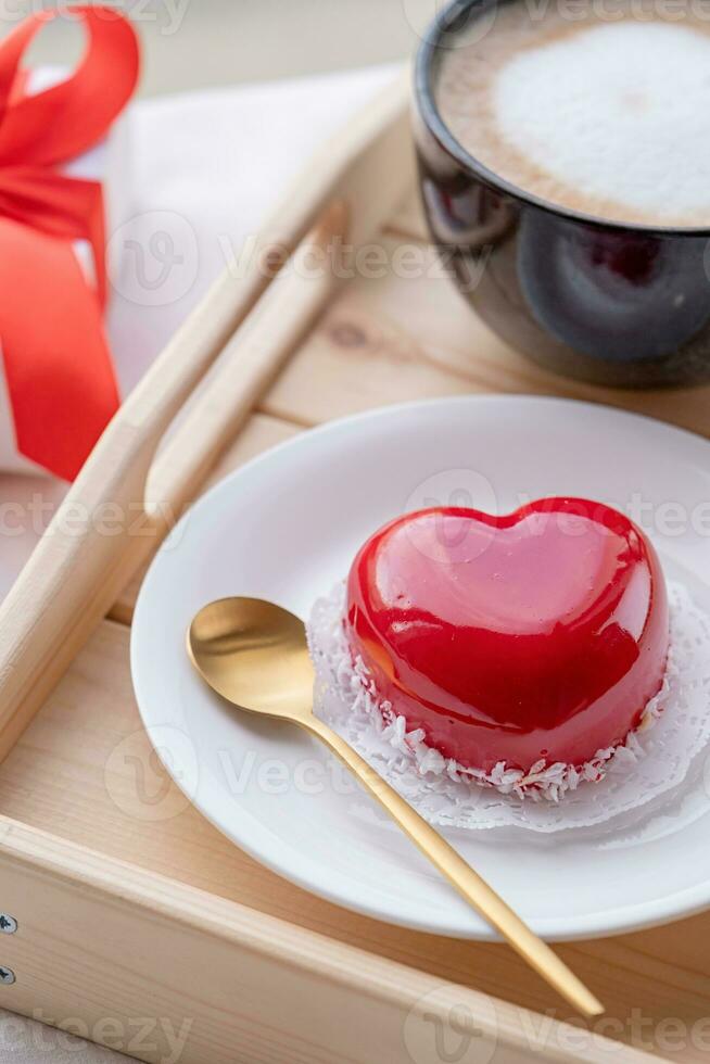 Herz geformt glasiert Valentinstag Kuchen im Bett auf hölzern Tablett foto