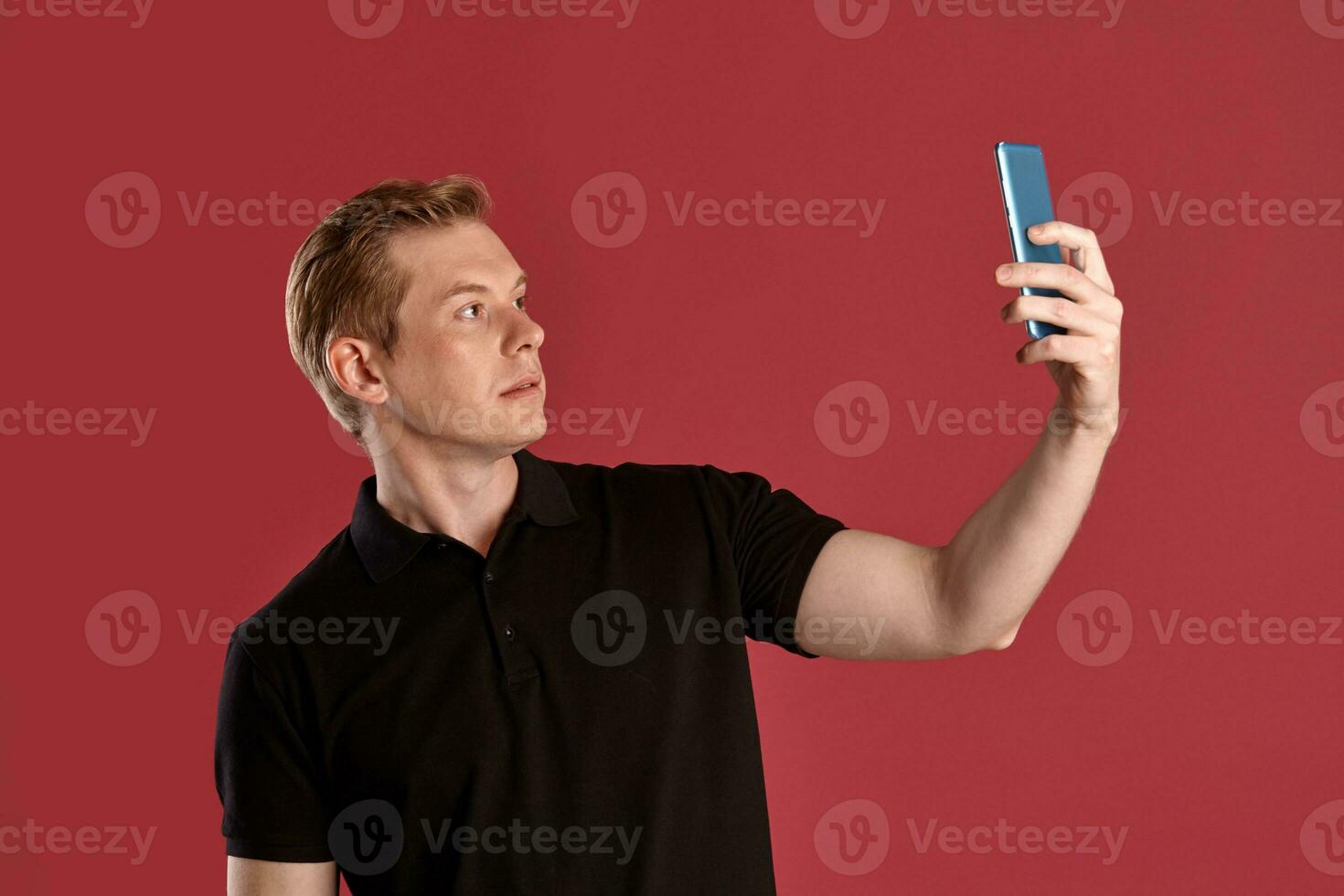 Nahansicht Porträt von ein Ingwer Kerl im schwarz T-Shirt posieren auf Rosa Hintergrund. aufrichtig Emotionen. foto