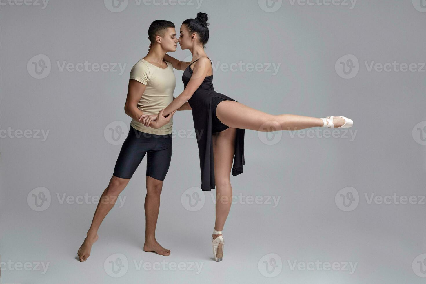 zwei sportlich modern Ballett Tänzer sind posieren gegen ein grau Studio Hintergrund. foto