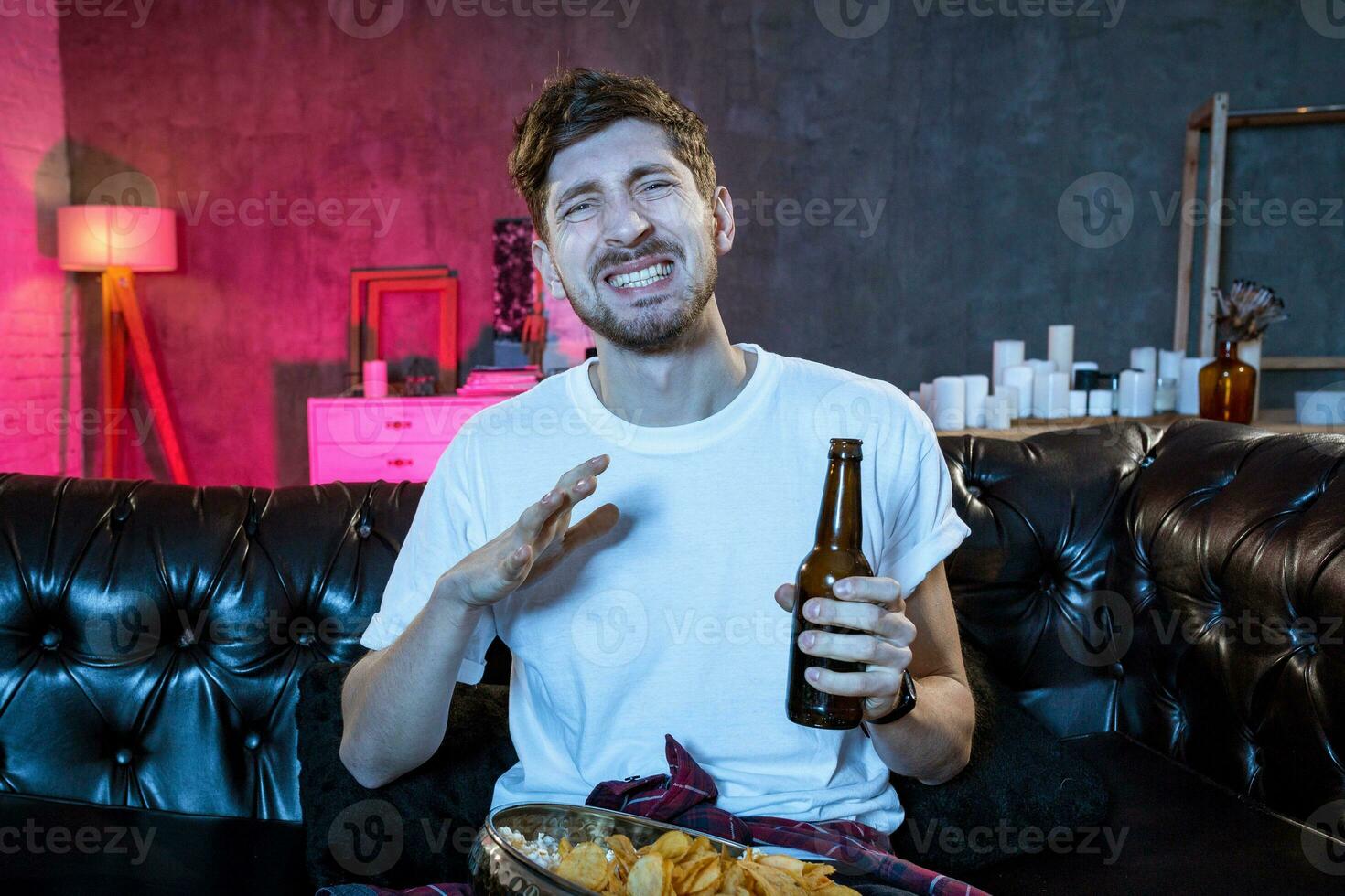 jung Fan Mann Aufpassen Fußball Spiel auf Fernsehen Sitzung foto