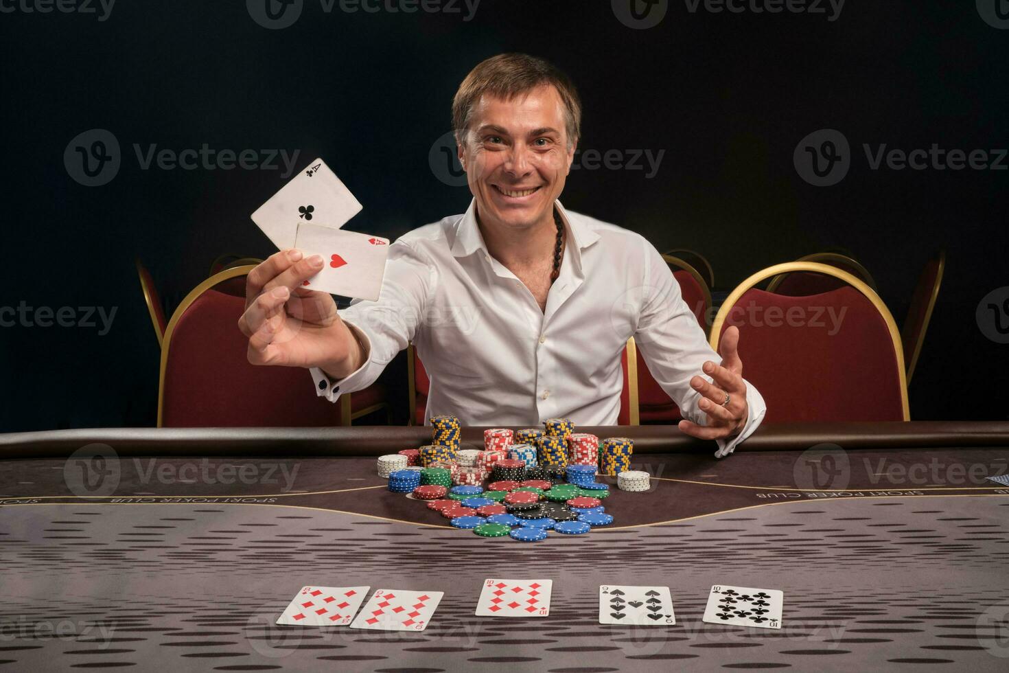 gut aussehend emotional Mann ist spielen Poker Sitzung beim das Tabelle im Kasino. foto