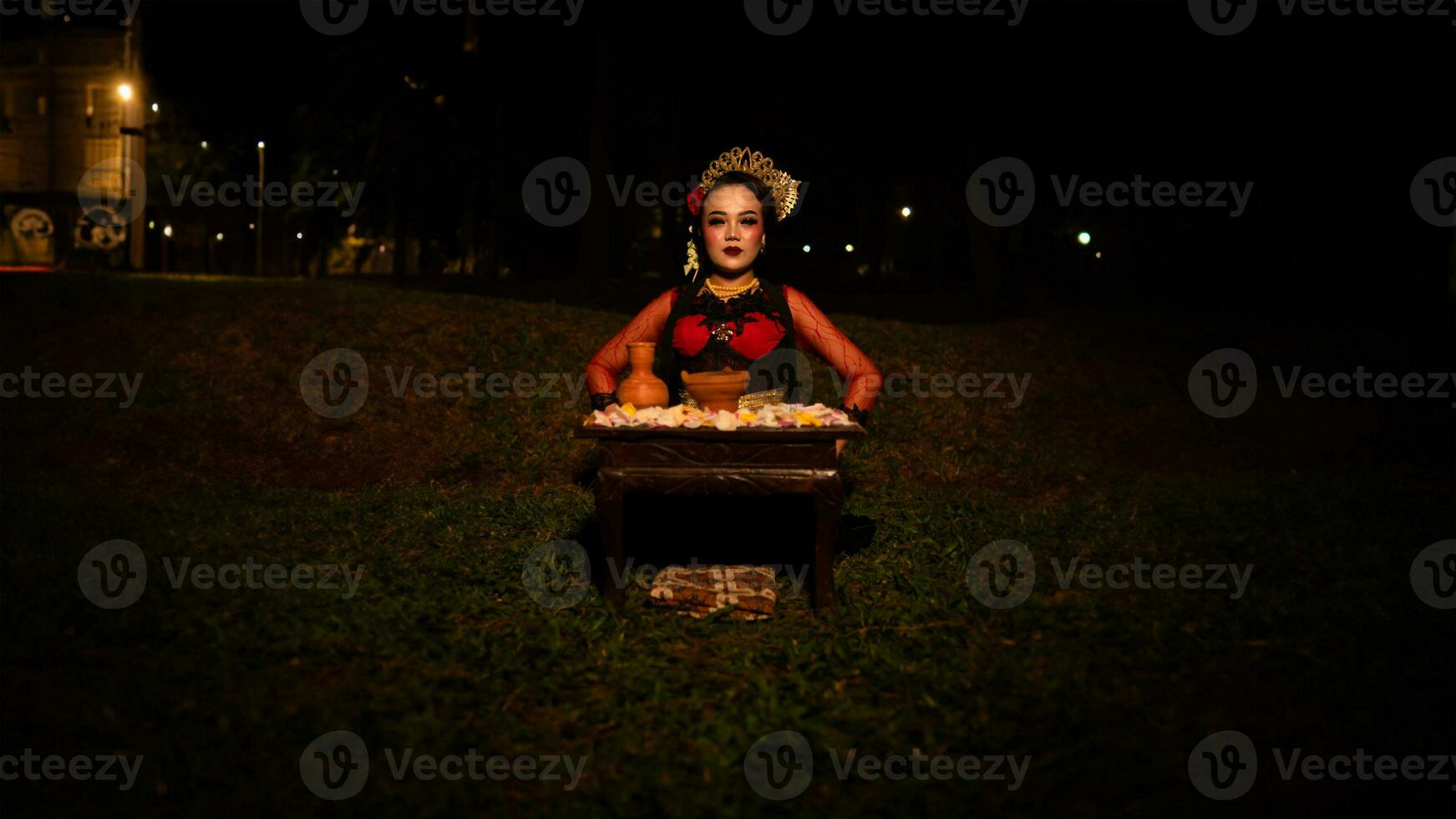 ein weiblich Tänzer Wer sieht aus schön im ein rot Kostüm führt aus ein Ritual Das strahlt ein Aura von Schönheit und Reinheit foto