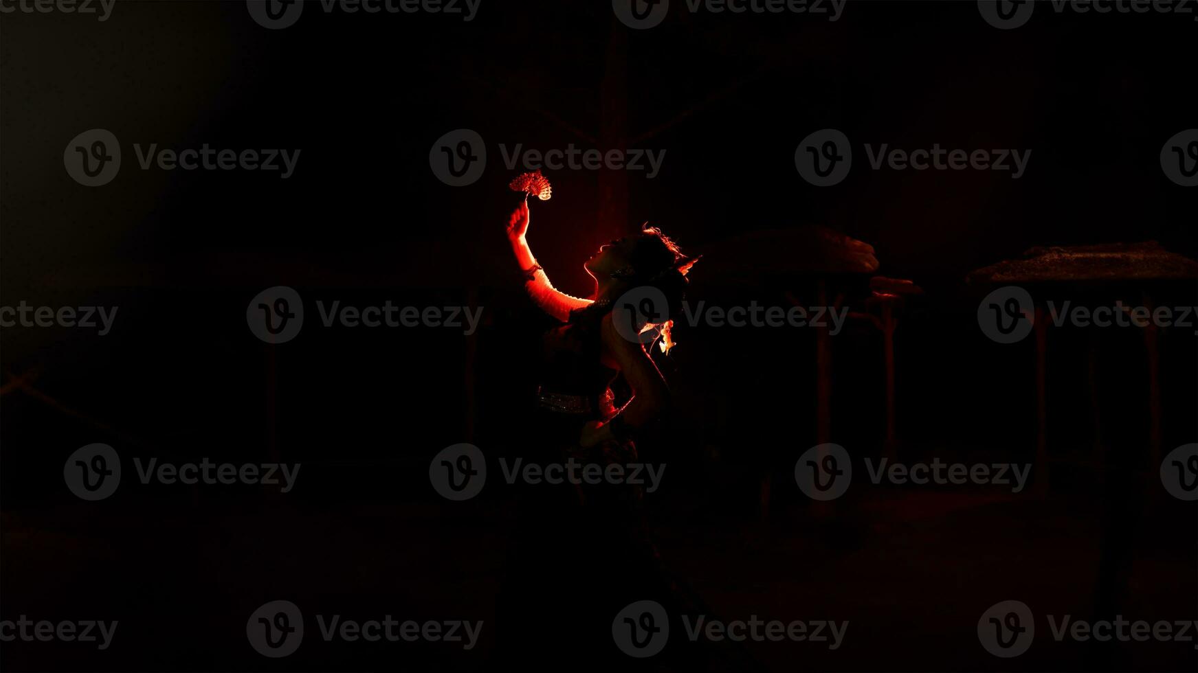 das Silhouette von ein weiblich Tänzer halten Schmuck Das sieht aus mögen ein Betrachtung reflektieren im das dim Licht foto