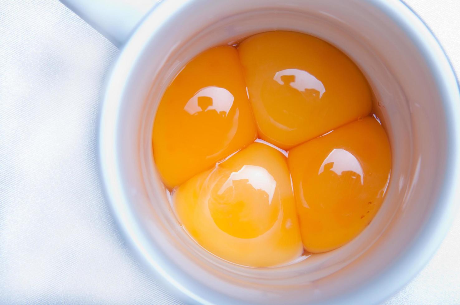 vier frische Eier zum Mischen mit weißem Hintergrund foto