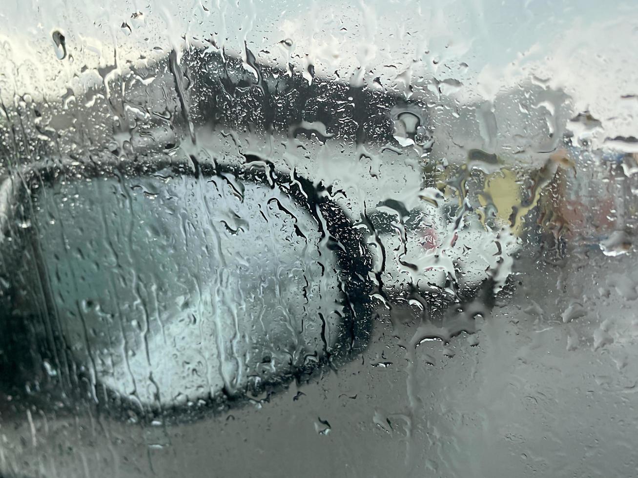 Regentropfen auf dem Autofenster auf dem Hintergrund des Spiegels foto