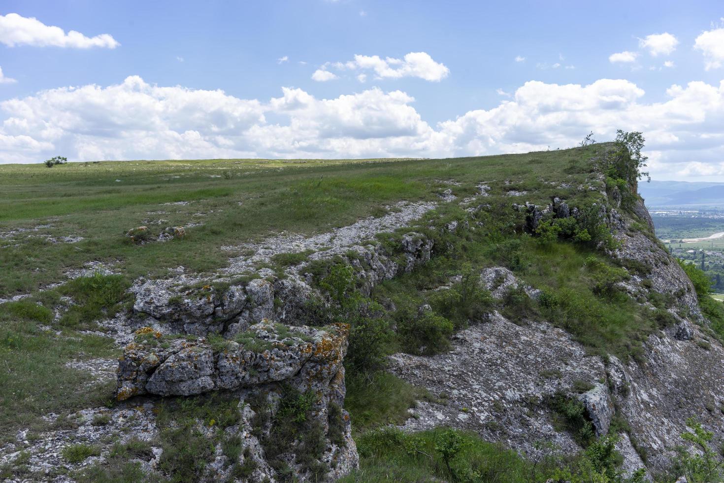 Naturlandschaft mit grüner Wiese unter blauem Himmel foto