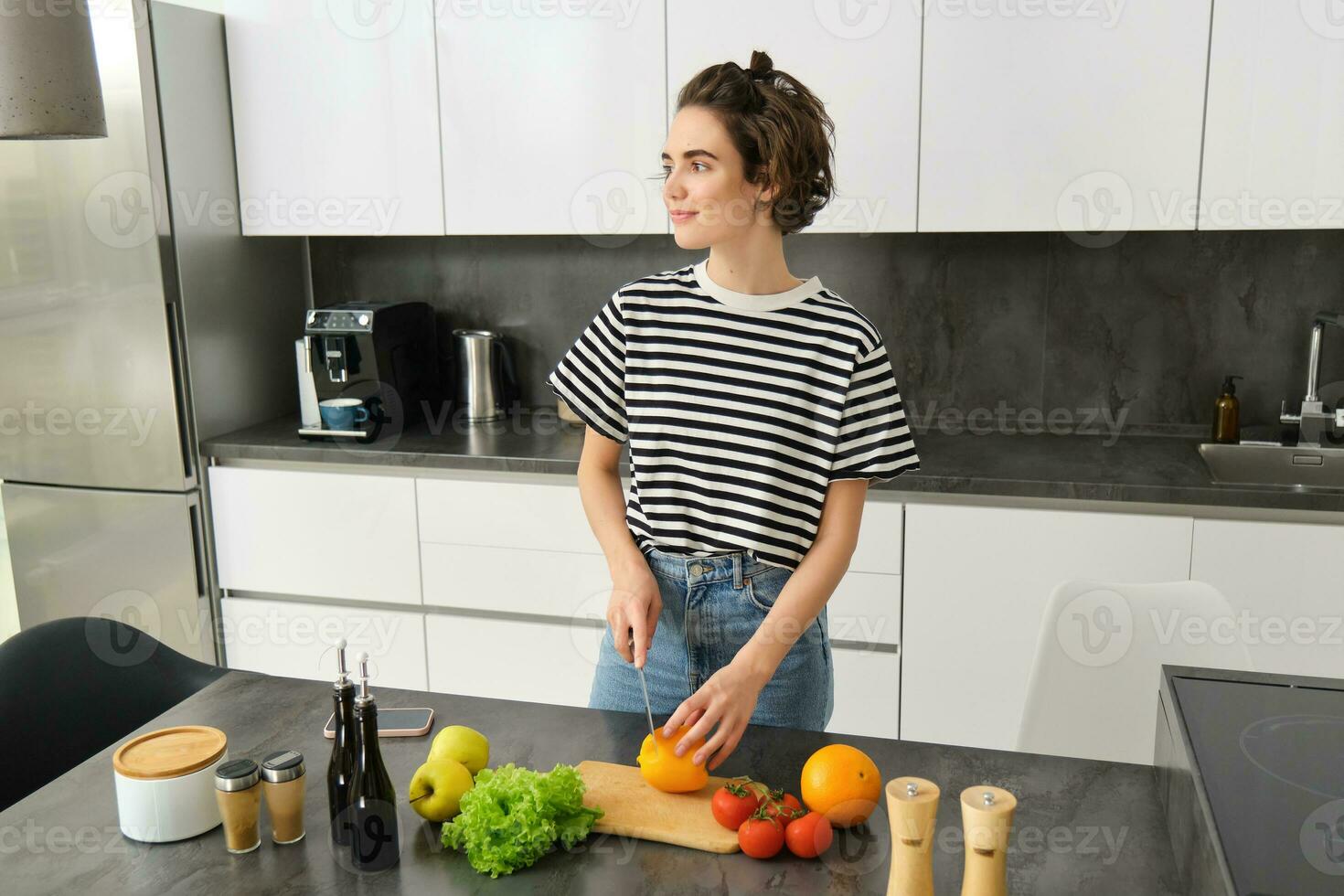 Porträt von jung weiblich Modell- Kochen im das Küche, Hacken Gemüse, vegan Mädchen vorbereiten Mahlzeit, gesund Diät Konzept foto