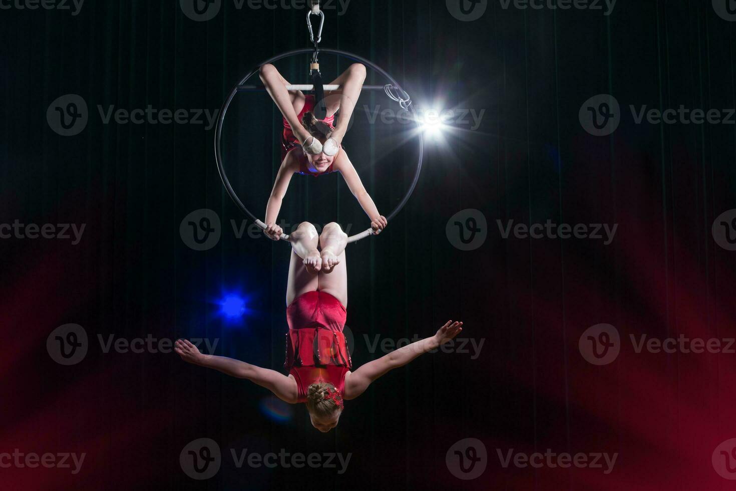 Zirkus Darstellerin Akrobat Leistung. zwei Mädchen ausführen akrobatisch Elemente im das Luft Ring. foto