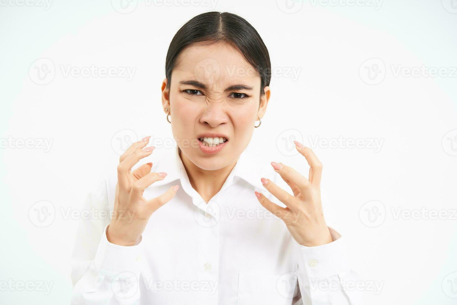 wütend Büro Dame, asiatisch Geschäftsfrau Geschrei und verkrampft Fäuste von Wut, schüttelt von frustriert, steht Über Weiß Hintergrund, verliert Temperament foto