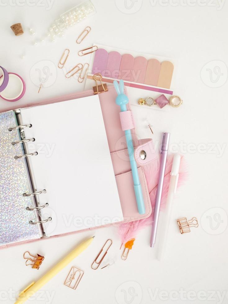 Tagebuch öffnet mit weißer und holografischer Seite. Rosa Planer mit süßem Briefpapier, das im Flatlay-Stil fotografiert. Draufsicht des rosa Planers mit Geschäftsbriefpapier. rosa Glamour-Planer Dekorationsfoto foto