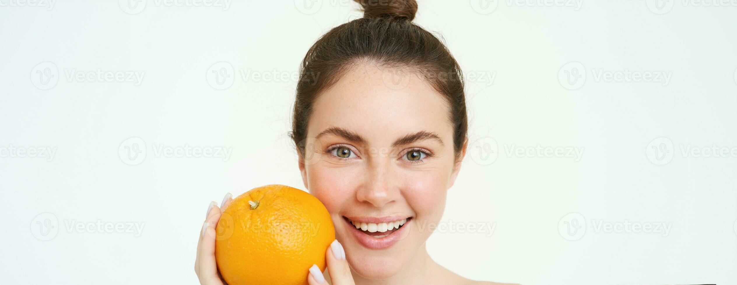 Vitamin c und Gesundheit Konzept. jung Schönheit Frau, halten Orange Obst in der Nähe von Gesicht, Konzept von organisch Hautpflege Behandlung, Gesichts- und Körper Produkte, Stehen Über Weiß Hintergrund foto