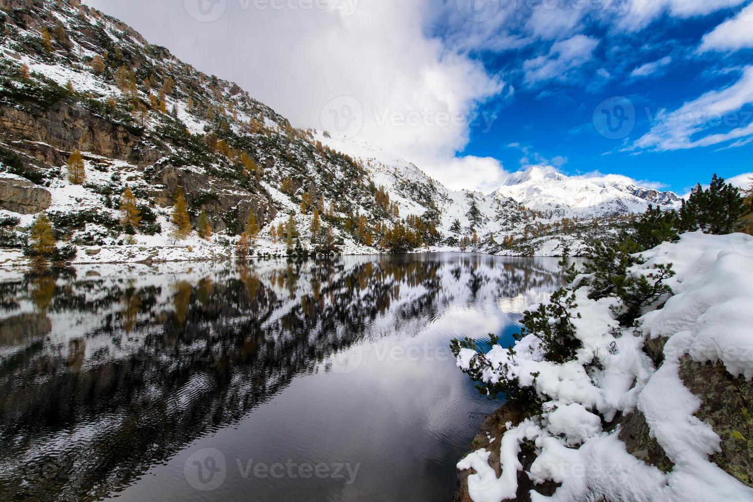 Berge und Alpensee mit Schneefall foto