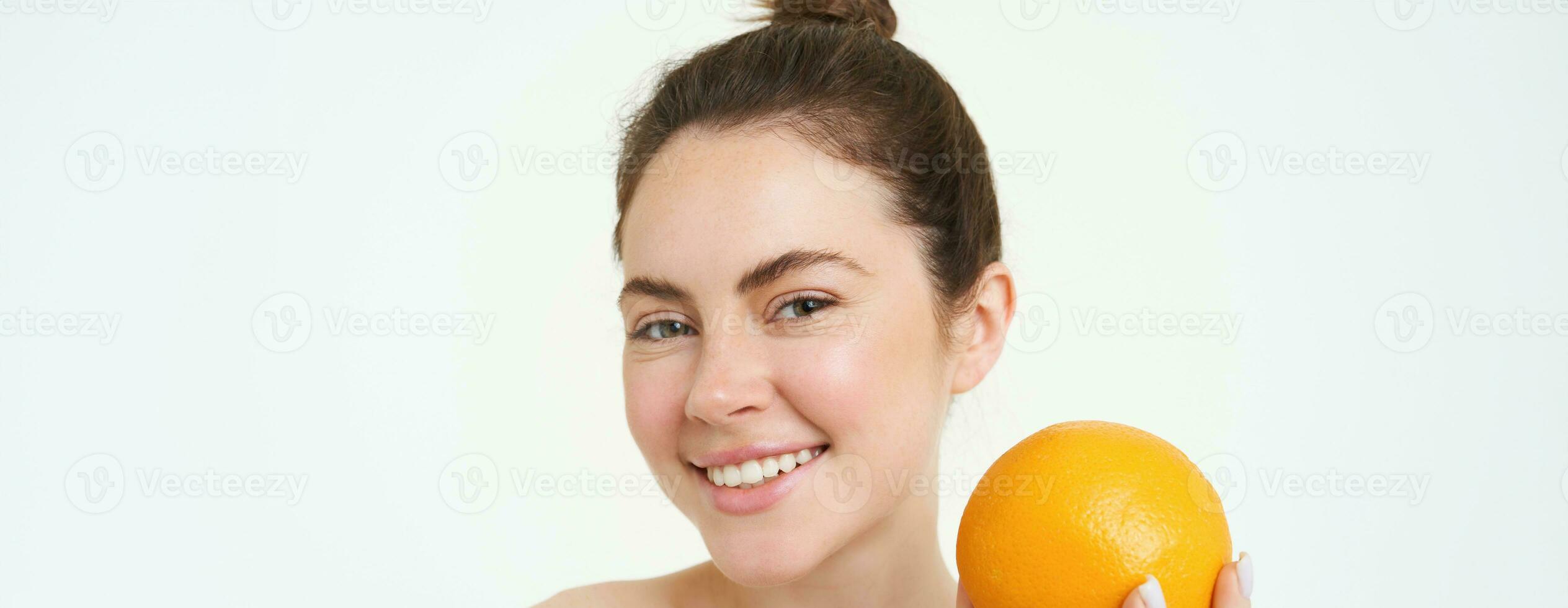 Vitamin c und Gesundheit Konzept. jung Schönheit Frau, halten Orange Obst in der Nähe von Gesicht, Konzept von organisch Hautpflege Behandlung, Gesichts- und Körper Produkte, Stehen Über Weiß Hintergrund foto