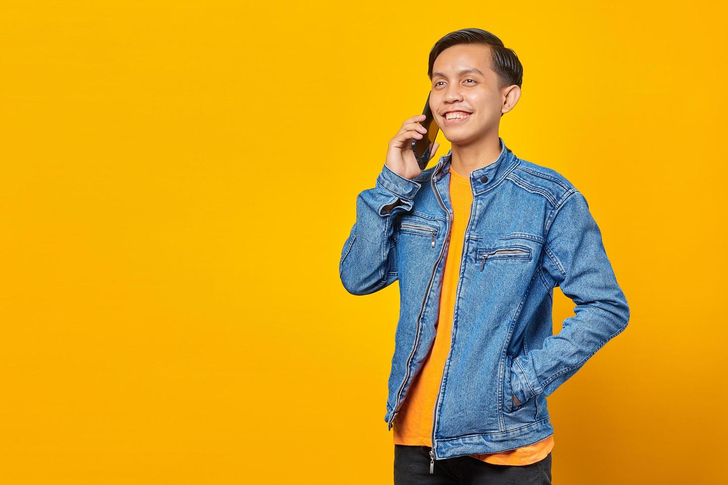 Porträt eines attraktiven asiatischen Mannes, der auf dem Smartphone spricht und glücklich aussieht foto