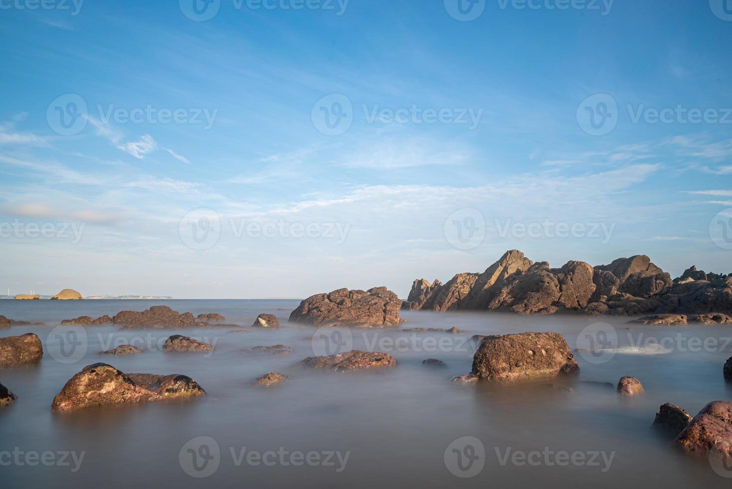 Meerwasser und Riffe am Meer unter blauem Himmel foto