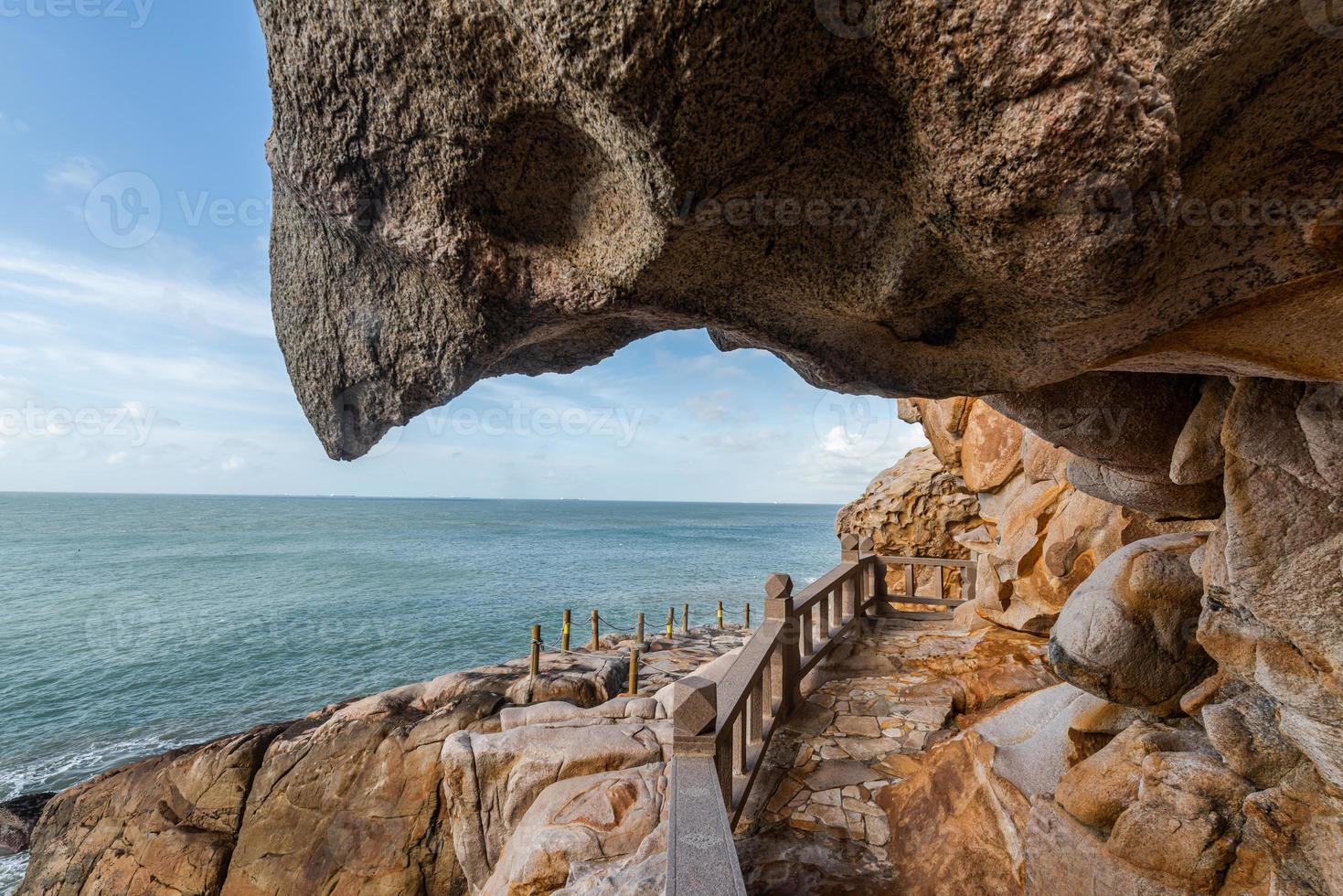 Steine in verschiedenen Formen, verwittert vom Meer unter blauem Himmel foto