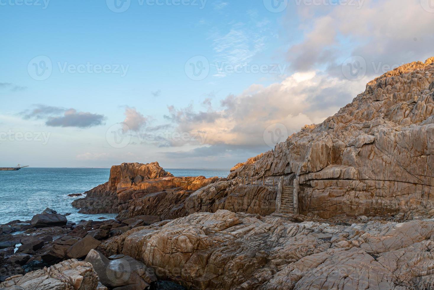 morgens scheint die sonne auf die felsen und wellen am strand foto