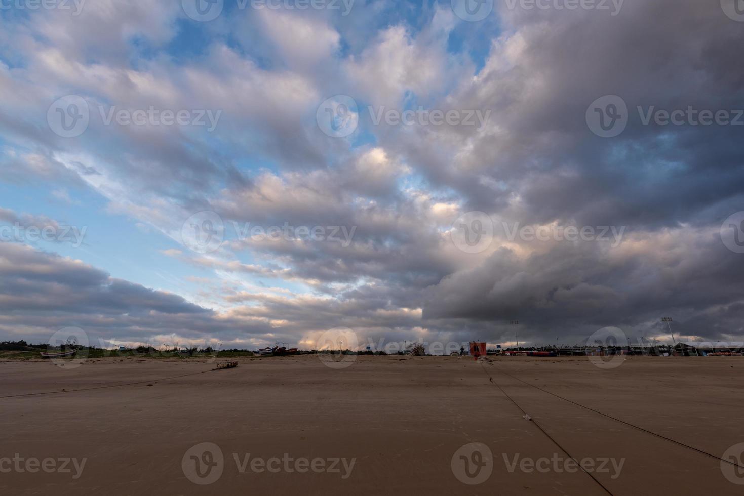 der Himmel ist mit dunklen Wolken bedeckt und der Strand ist bewölkt foto