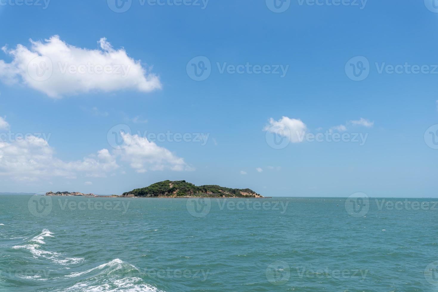 das Meer und die Küste unter blauem Himmel und weißen Wolken foto