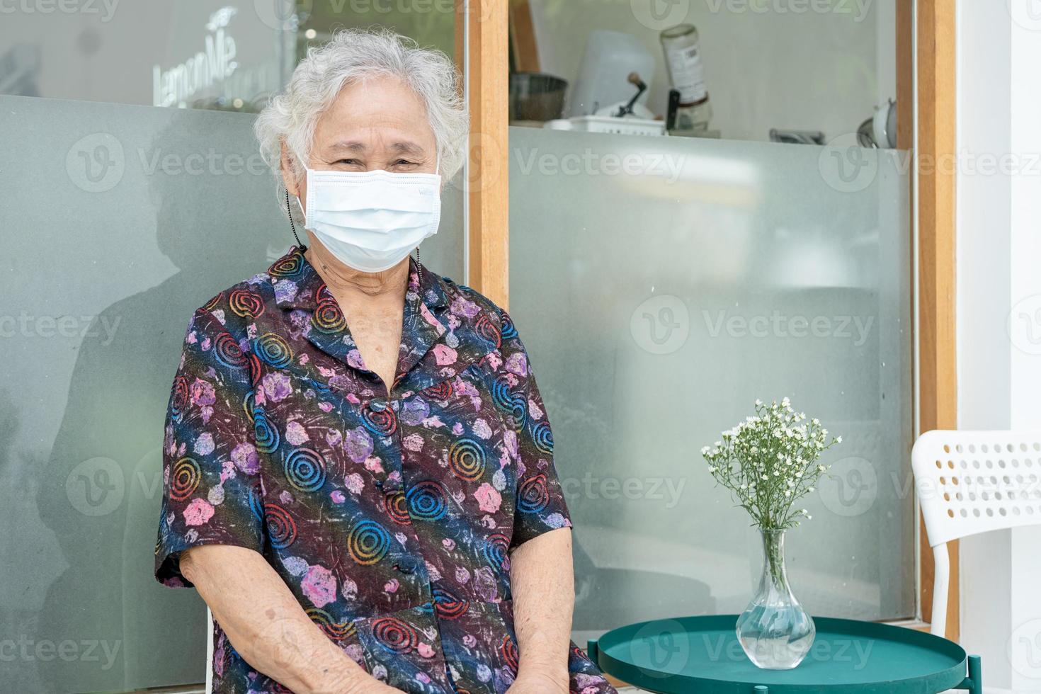 asiatische senior oder ältere alte damenpatientin, die im krankenhaus eine neue normale gesichtsmaske trägt, um die sicherheitsinfektion covid-19 coronavirus zu schützen foto