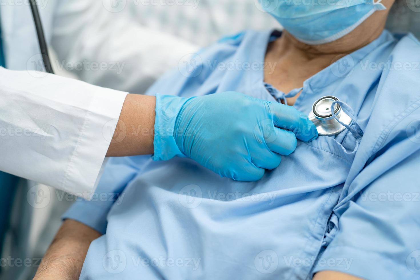 Arzt hilft asiatischen Senioren oder älteren Patienten, die im Krankenhaus eine Gesichtsmaske tragen, um die Sicherheitsinfektion zu schützen und das Covid-19-Coronavirus abzutöten. foto