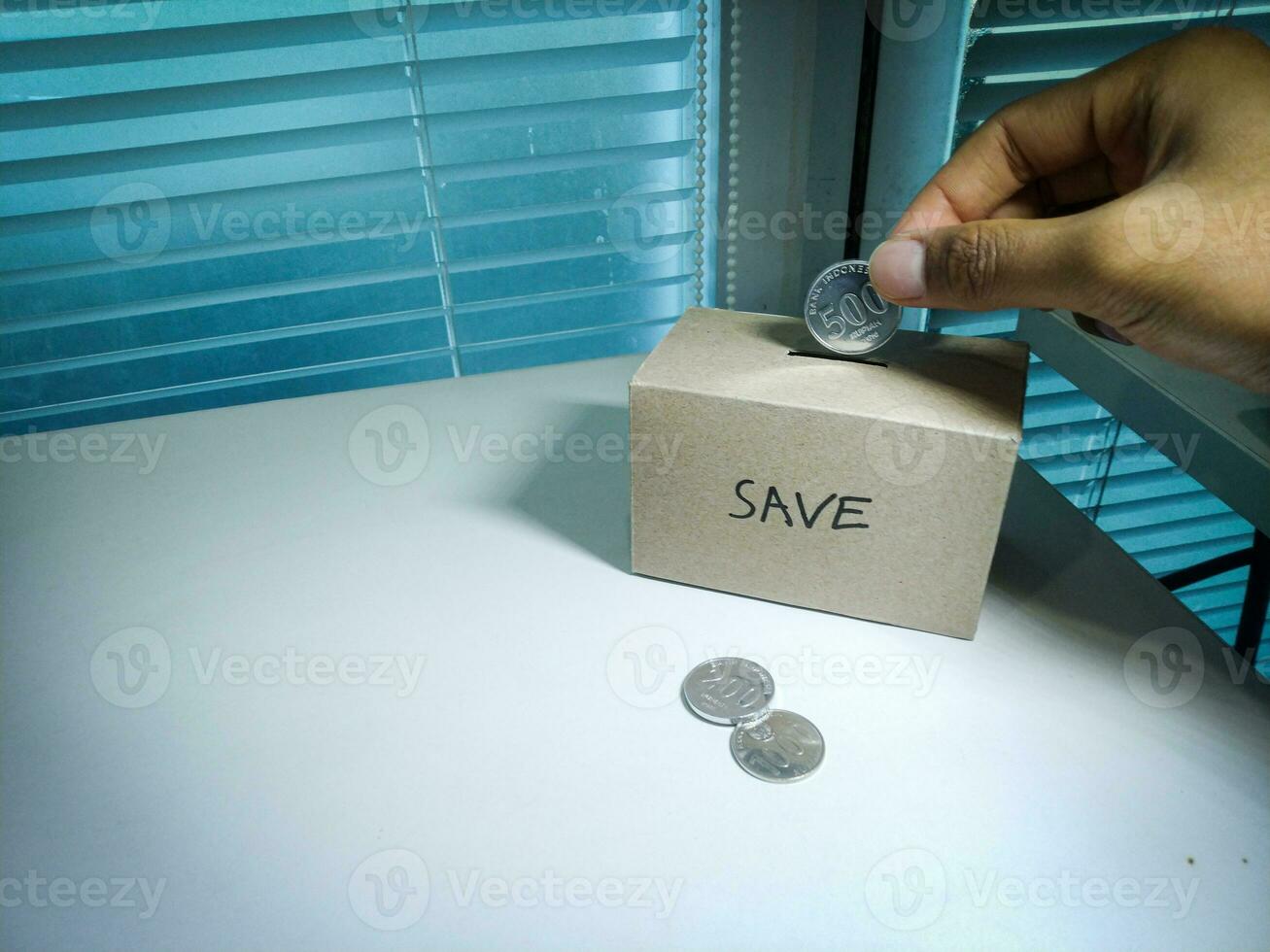 Speichern Geld mit Hand Putten Münzen im ein Box Ersparnisse foto
