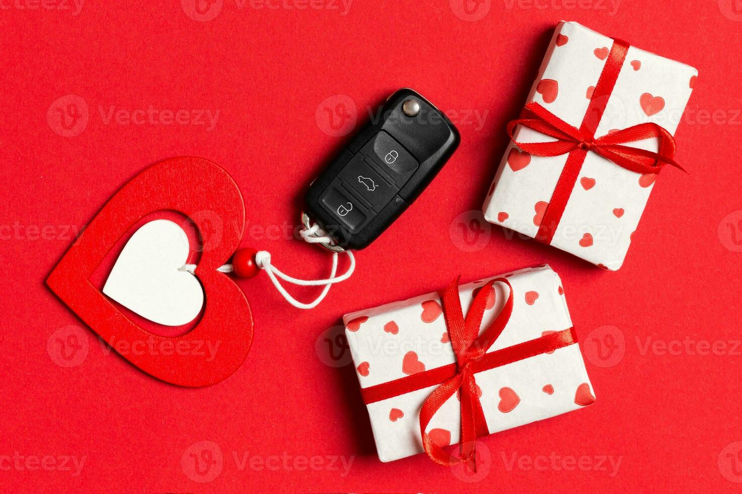 Draufsicht auf Autoschlüssel, Geschenkboxen und Spielzeugherz auf buntem Hintergrund. valentinstagkonzept mit kopierraum foto