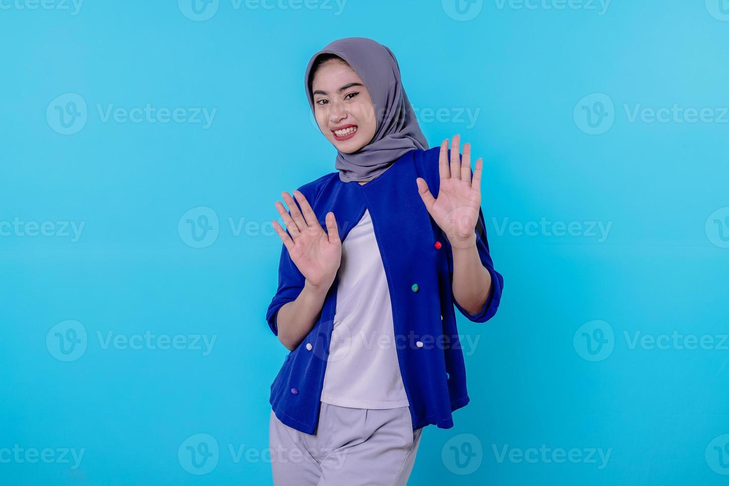 ausgeflippt schockiert und erstaunt junge Frau, die Hijab trägt, indem sie aus geschüttelten Händen schreit foto