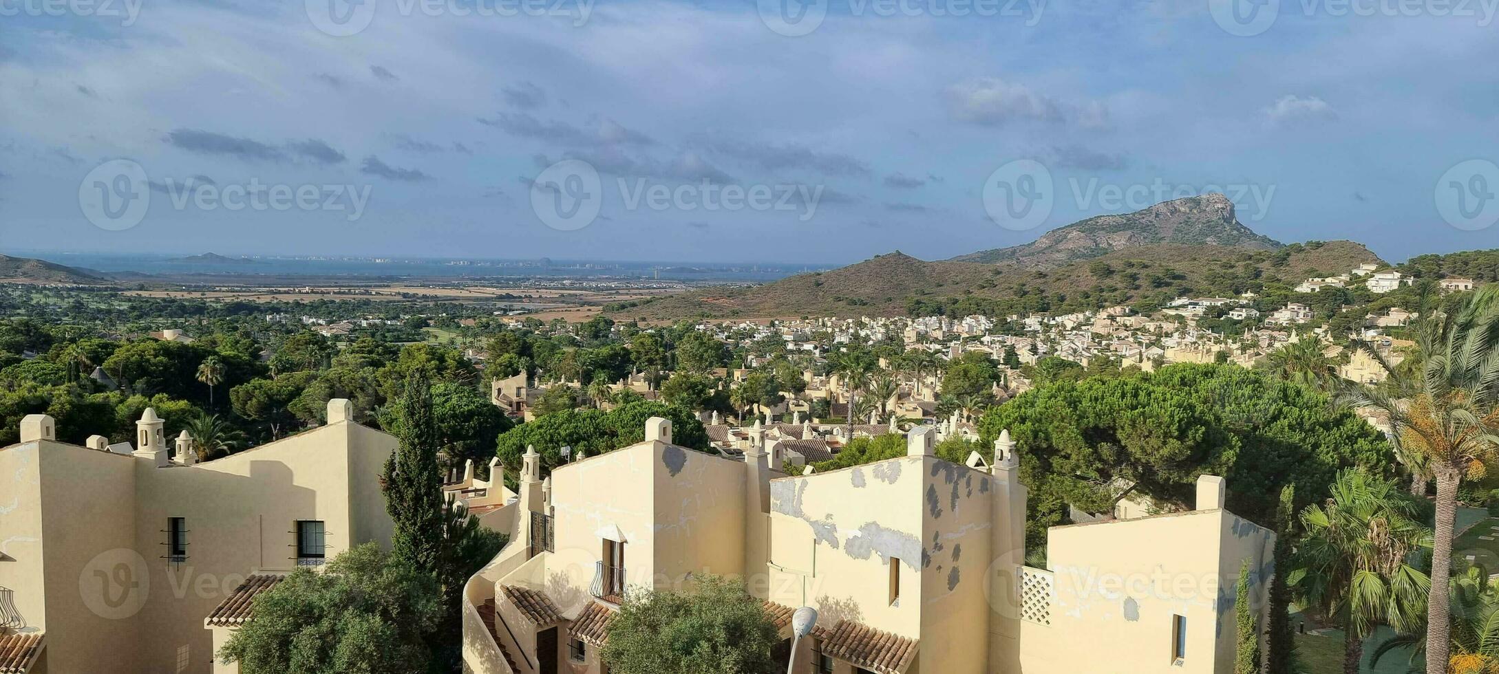 Panorama- Aussicht von ein Mittelmeer Landschaft mit Wohn Gebäude und ein Berg im das Hintergrund unter ein klar Himmel. foto