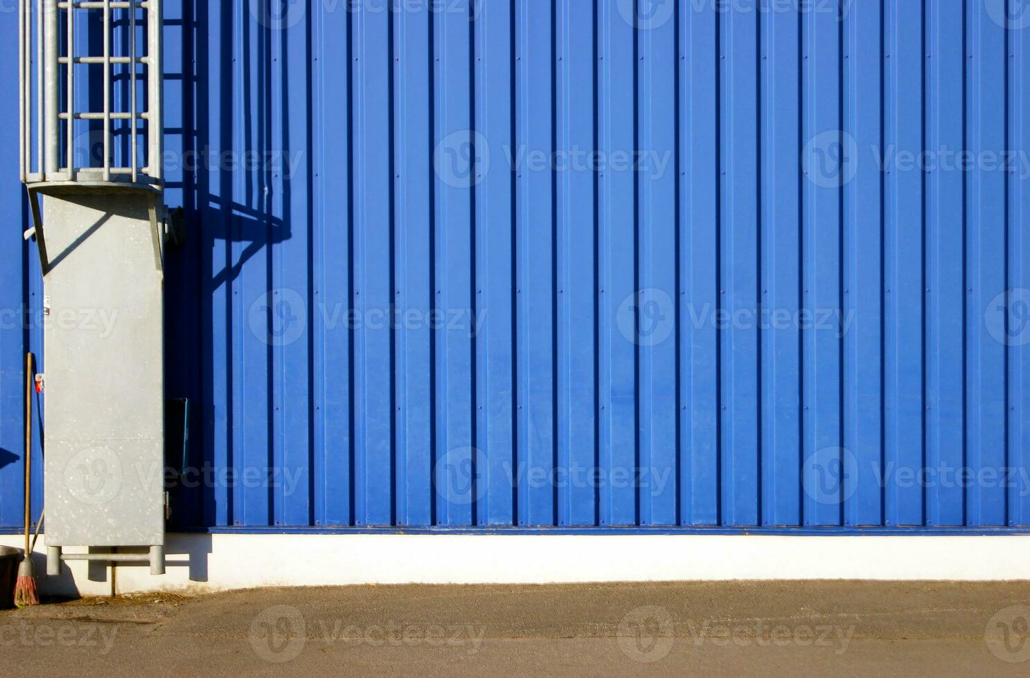 Blau Hintergrund Metall Mauer Abstellgleis, Verkleidung mit Treppe zu das Dach. foto