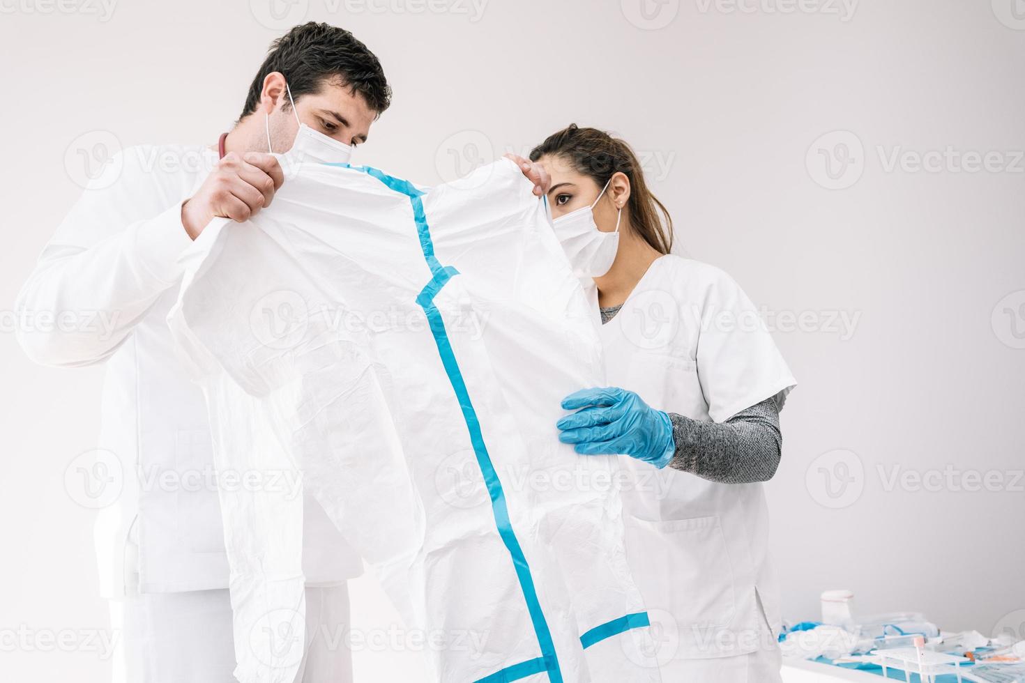 Sanitäter in Masken stehen im Raum mit Schutzkostüm foto