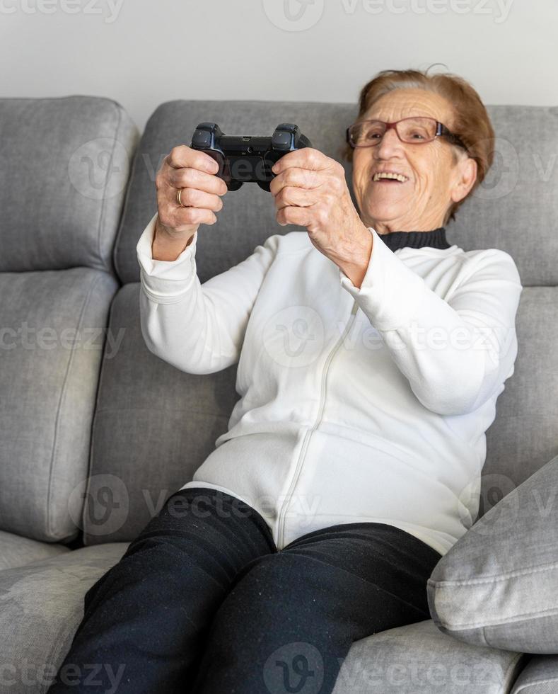 fröhliche ältere Frau, die Videospiel spielt foto