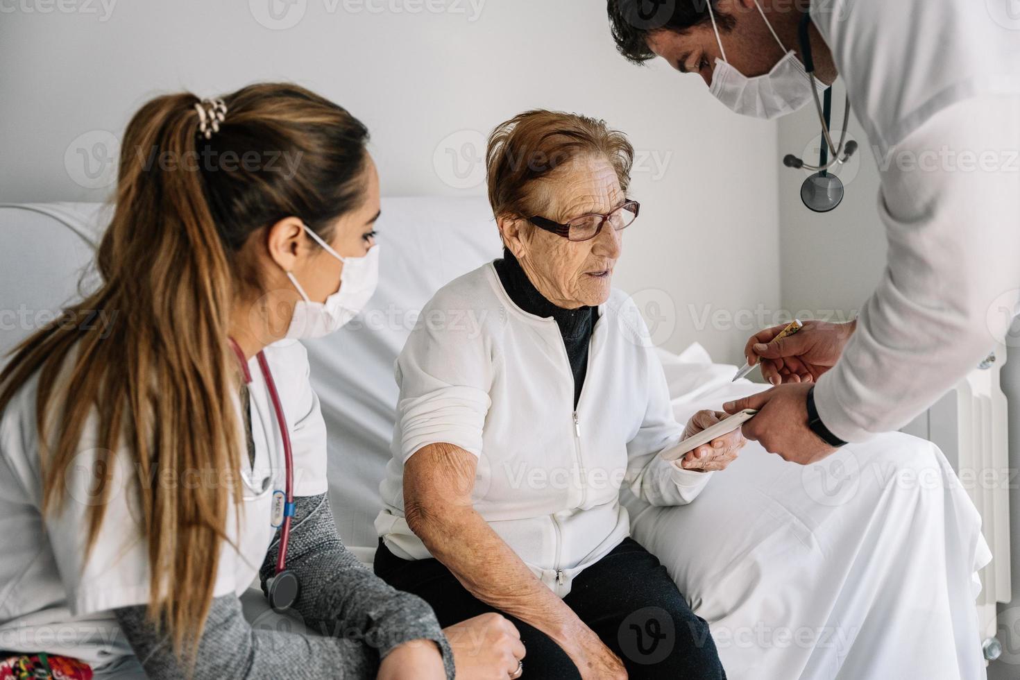 ältere Frau, die Dokumente für medizinisches Verfahren unterschreibt foto