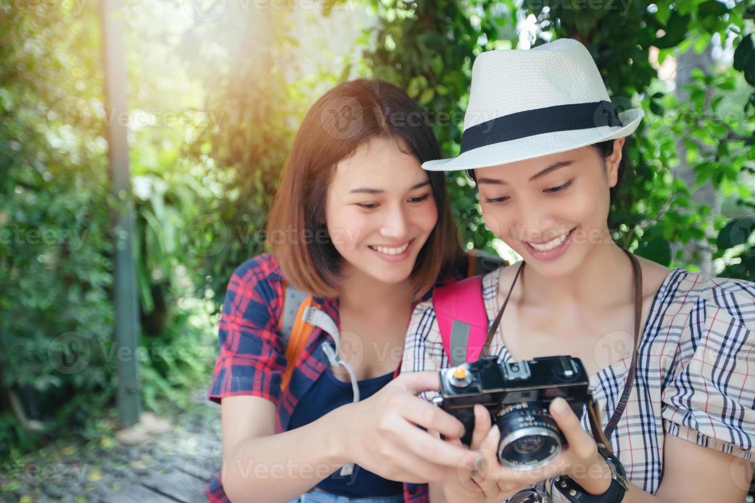 Asiatische Frauenrucksäcke, die zusammen gehen und glücklich sind, machen Fotos und schauen Bild, entspannen Sie sich auf Urlaubskonzeptreisen