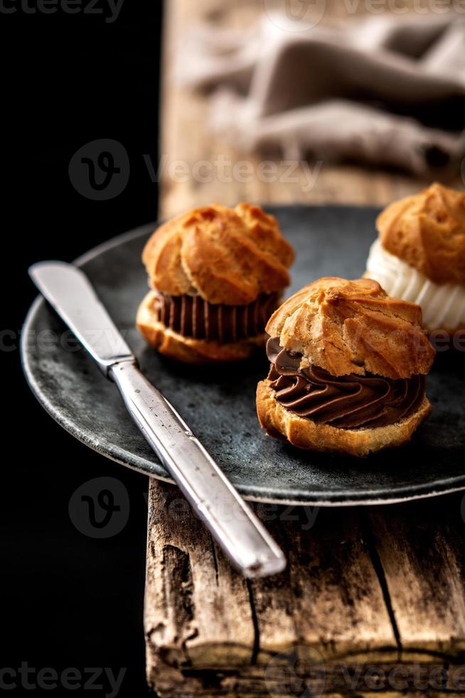 leckere Profiteroles auf rustikalem Holztisch foto